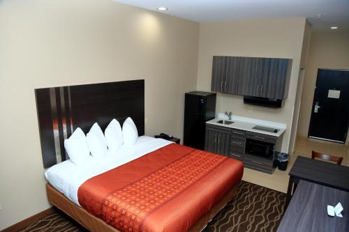 a hotel room with a bed and a sink at Americas Best Value Inn & Suites-Prairieville in Prairieville 