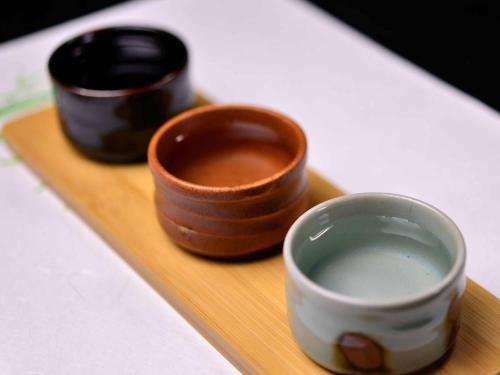 a wooden tray with two wooden cups on it at Bingoya in Kurashiki