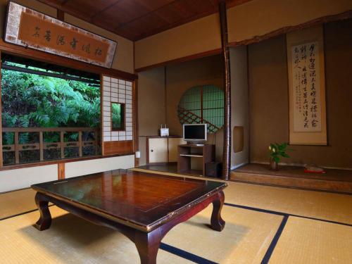 a living room with a table and a television at Bingoya in Kurashiki