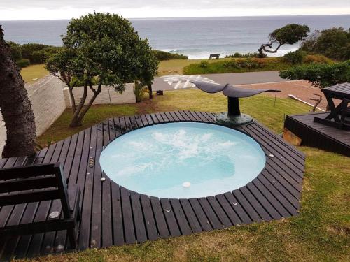 a small swimming pool on a wooden deck with a bench at Whales Way Ocean Retreat in Wilderness