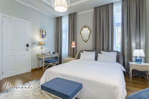 sypialnia z dużym białym łóżkiem i niebieskim stołkiem w obiekcie Villa Promenade w Burgas