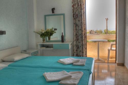 a bedroom with a bed with two towels on it at Esperides Hotel in Myrtos