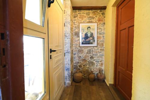 a hallway with a stone wall and a door at Kaldi's Traditional House in Kastamonítsa