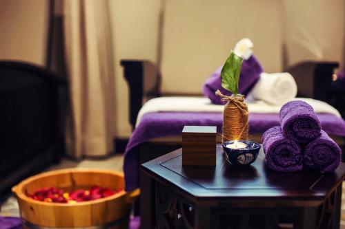 a room with a bed and a table with purple towels at Laluna Hoi An Riverside Hotel & Spa in Hoi An