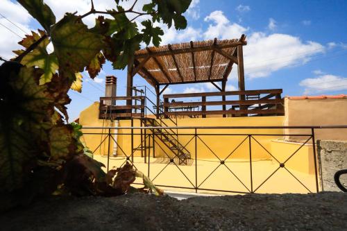 a yellow building with a wooden structure on top of it at Kaldi's Traditional House in Kastamonítsa