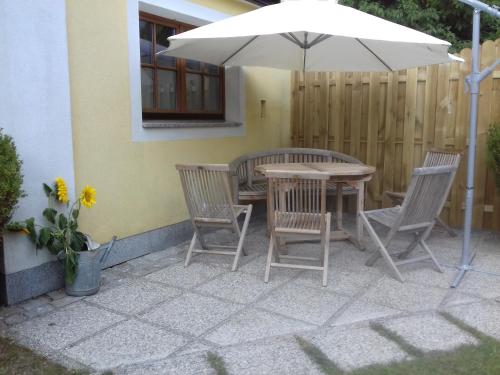 a table and chairs and an umbrella on a patio at Ferienwohnung Wiesmühlstrasse in Henndorf am Wallersee