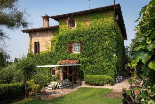 a house covered in ivy with a yard at Torre de Salis in Gussago