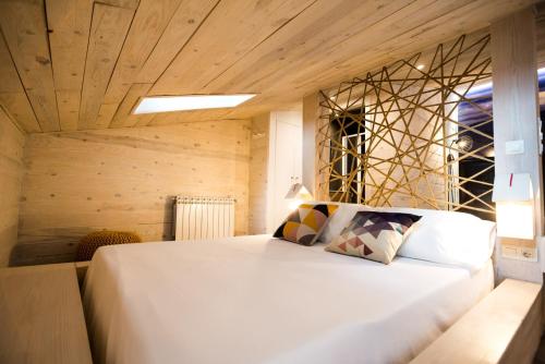 a bedroom with a large white bed with wooden ceilings at Font Catxa in Morella