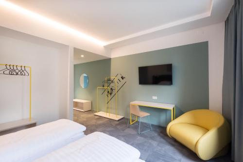 a bedroom with a bed and a chair and a desk at Airbase Hotel in Kalsdorf bei Graz