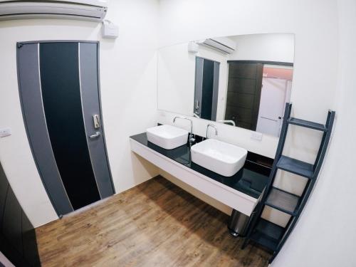 łazienka z dwiema umywalkami i lustrem w obiekcie 放個Jia w mieście Taidong