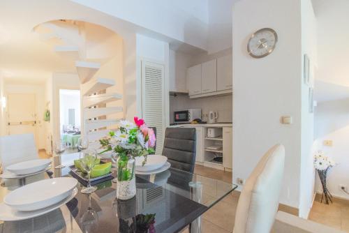 kuchnia i jadalnia ze szklanym stołem i krzesłami w obiekcie Apartamento Ferrera Park 623 w mieście Cala Ferrera