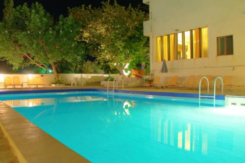 a swimming pool at night with a person in the water at Esperides Hotel in Myrtos