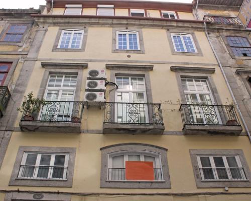 a building with windows and balconies on a street at Grande Oceano Guest House in Porto