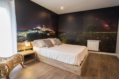 - une chambre avec un lit orné d'une peinture murale dans l'établissement Sant Joan, à Morella