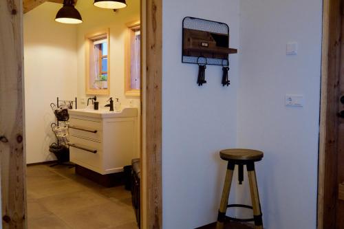 a bathroom with a sink and a stool in it at Íslandsbærinn /Old Farm in Akureyri