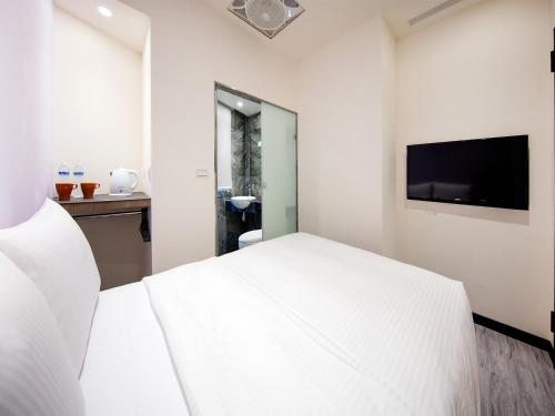 a hotel room with a television and a bed at 巧爾行旅 Ciaoer APT in Taipei
