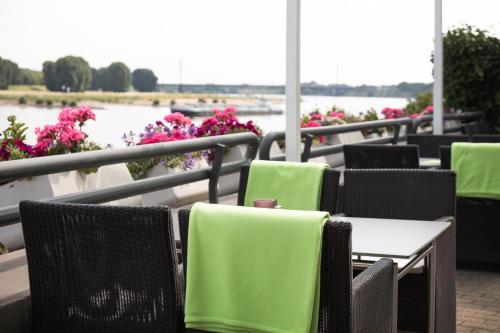a row of chairs and tables with pink flowers at Hotel Rheingarten in Duisburg