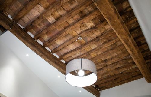a ceiling with wooden beams and a light fixture at Vicolo del Geppone in Lucca