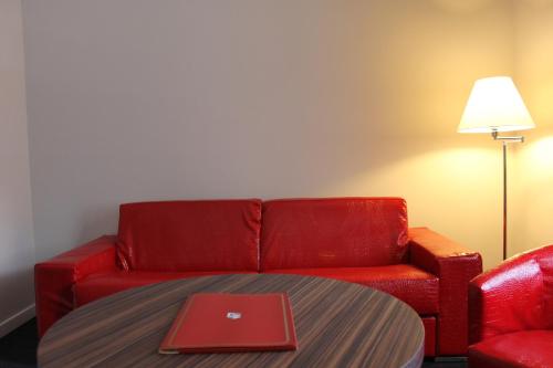 a red couch and a table with a laptop on it at La Fonte dell'Astore in Castelpetroso