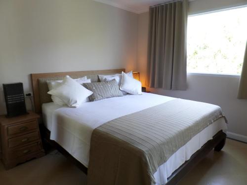 a bedroom with a large white bed with a window at Westbury Residence in Pattaya South