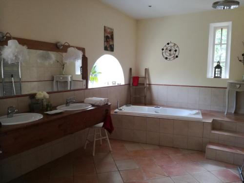 une salle de bain avec deux lavabos et une baignoire dans l'établissement Mon Petit Soulié, à Loupia