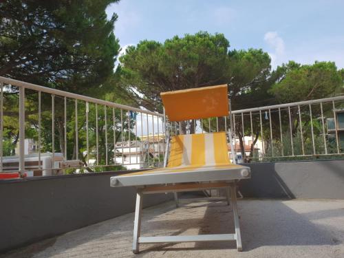 a yellow and white chair sitting on a balcony at Hotel Villa Dina in Lido di Jesolo