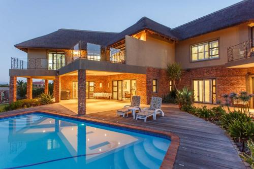 a house with a swimming pool in front of it at Karoo-Palet in Oudtshoorn