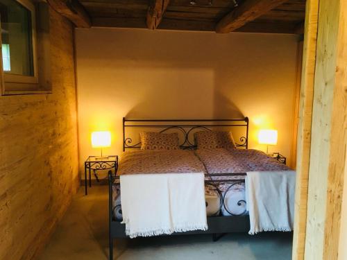a bedroom with a bed with two lamps on either side at Giferspitz Gstaad in Gstaad