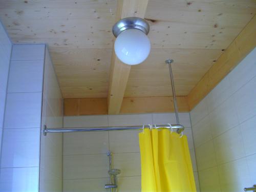 een douche met een geel douchegordijn en een licht bij Bungalows am Sonnencamping Albstadt - oberhalb Badkap in Albstadt