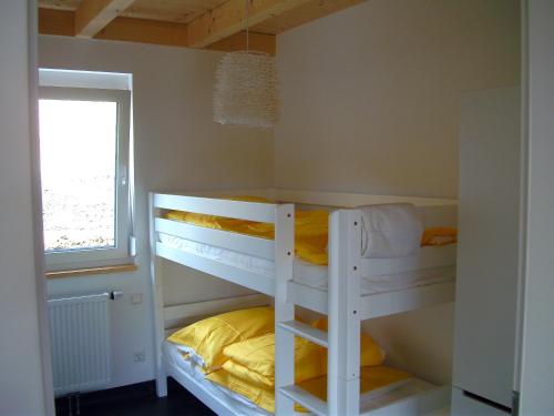 2 Etagenbetten in einem Zimmer mit Fenster in der Unterkunft Bungalows am Sonnencamping Albstadt - oberhalb Badkap in Albstadt