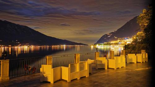a view of the lake and mountains at night at Villa Romantica Hotel in Limone sul Garda