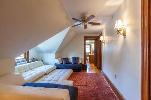 a living room with a couch and a ceiling fan at Charming Harvard Victorian in Cambridge