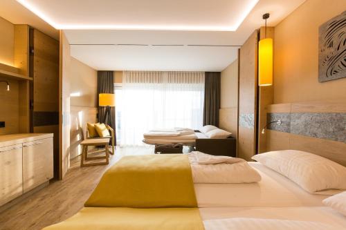 a hotel room with two beds and a window at AIGO Welcome Family Resort in Aigen im Mühlkreis