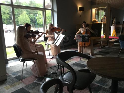a group of women playing instruments in a room at Novotel Manchester West in Worsley
