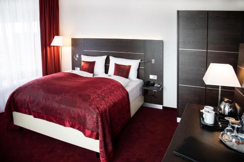 ein Hotelzimmer mit einem großen Bett und einem Schreibtisch in der Unterkunft Hotel Rheingarten in Duisburg