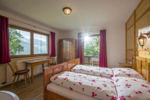 a bedroom with two beds and a table and a window at Haus Moidl in Stummerberg