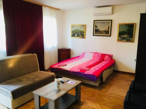Habitación con cama, sofá y mesa. en Apartments Konak, en Visoko