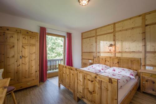 a bedroom with a bed with wooden walls and a window at Haus Moidl in Stummerberg