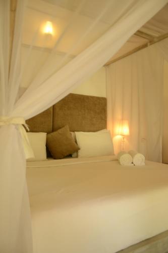 a bedroom with a white bed with a canopy at Handun Villas in Talalla