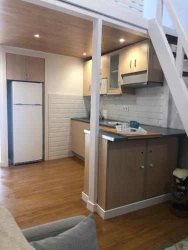 uma cozinha com armários de madeira e um frigorífico branco em Bungalow Laredo em Laredo