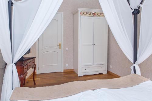 a bedroom with a bed and a dresser and a door at Hotel Nata in Tbilisi City