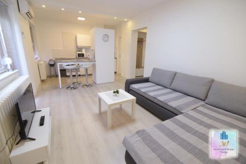 a living room with a couch and a table at 3M Apartment Skopje Center in Skopje