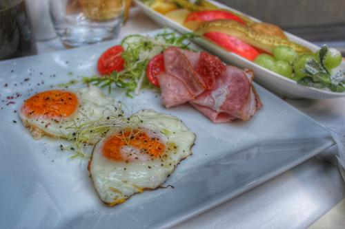 un plato de comida con huevos, carne y fruta en Hotel Telč, en Telč