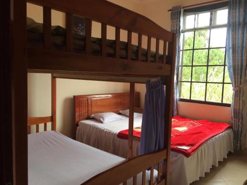 a bedroom with two bunk beds and a window at Dalat Happy Hostel in Da Lat