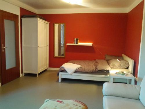 um quarto com uma cama e uma parede vermelha em Oerlihome em Oerlinghausen