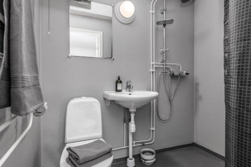 a white bathroom with a sink and a shower at Tallbackens Gård & Vandrarhem in Svärtinge