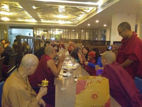 a group of monks sitting at a table in a room at Maya Heritage in Bodh Gaya