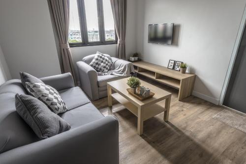 a living room with a couch and a table at Carnation Residence in Samut Prakan