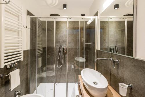 ein Bad mit einer Dusche, einem WC und einem Waschbecken in der Unterkunft CIMA 11 & SASS PORDOI - Apartments in Moena