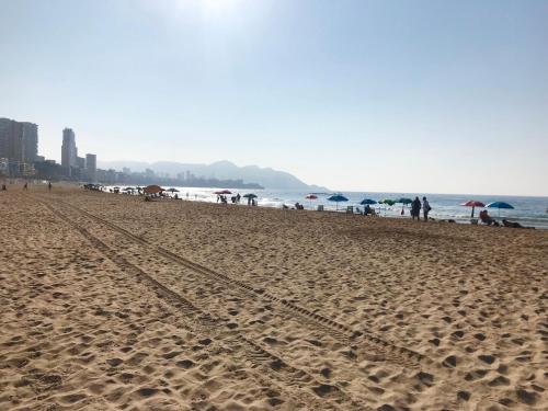 a beach with people and umbrellas and the ocean at Sunset Drive Vistas Magicas in Benidorm